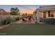 Backyard showcasing a putting green, hot tub, patio, and lush desert landscaping at 28249 N Shundeen Cir, San Tan Valley, AZ 85143