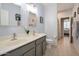 Bright bathroom with double sinks, a large mirror, and a view into the hall at 28249 N Shundeen Cir, San Tan Valley, AZ 85143