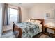 Cozy bedroom with a wood frame bed, wood-look floors, and natural light from a window at 28249 N Shundeen Cir, San Tan Valley, AZ 85143