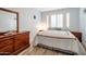 Comfortable bedroom featuring wood-look flooring, a large window, and a mirrored dresser at 28249 N Shundeen Cir, San Tan Valley, AZ 85143