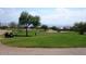 Scenic view of golf course with mature trees and golfers enjoying a round on a sunny day at 28249 N Shundeen Cir, San Tan Valley, AZ 85143