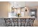 Open kitchen with breakfast bar provides seating, stylish pendant lighting, and bright white cabinetry at 28249 N Shundeen Cir, San Tan Valley, AZ 85143