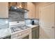 Close up of gas cooktop and stainless vent hood over the range in this updated kitchen at 28249 N Shundeen Cir, San Tan Valley, AZ 85143