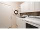 Bright laundry room features modern washer and dryer units and white cabinets at 28249 N Shundeen Cir, San Tan Valley, AZ 85143