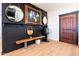 Stylish entryway with black accent wall, wooden bench, and dark wood door at 30439 W Peakview Rd, Wittmann, AZ 85361