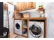 Well-organized laundry room with stacked washer and dryer and ample storage shelving at 30439 W Peakview Rd, Wittmann, AZ 85361