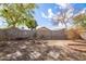 A xeriscaped backyard featuring mature trees, rock landscaping, a fire pit and a block wall for privacy at 3151 W Donald Dr, Phoenix, AZ 85027