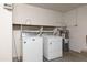 Functional laundry area includes washer, dryer, water heater, and storage shelves at 3151 W Donald Dr, Phoenix, AZ 85027