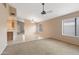 Spacious living room features neutral carpet, ceiling fan, and views of the kitchen at 3151 W Donald Dr, Phoenix, AZ 85027