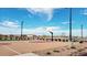 Outdoor community basketball court, featuring lighting, gravel landscaping, and nearby residential homes at 32637 N Newby Dr, San Tan Valley, AZ 85143