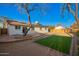 Expansive backyard featuring artificial grass, a stone patio, and mature desert landscaping at 331 W Stanford Ave, Gilbert, AZ 85233