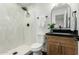 Modern bathroom featuring white tiled walls, a black shower head, and a wooden vanity at 331 W Stanford Ave, Gilbert, AZ 85233