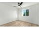 Bright, minimalist bedroom with wood flooring, a modern ceiling fan, and a view from the window at 331 W Stanford Ave, Gilbert, AZ 85233