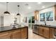 Open kitchen featuring light wood cabinets, black countertops, stainless steel appliances, and an island at 331 W Stanford Ave, Gilbert, AZ 85233