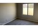 Bedroom with neutral carpet, window offering natural light and a view of the home exterior at 3703 N Wintergreen Way, Avondale, AZ 85392