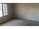 Cozy bedroom with a large window, neutral walls, and carpet flooring at 3703 N Wintergreen Way, Avondale, AZ 85392