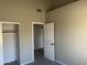 Bedroom with beige walls, a white door, and carpet flooring. A closet is visible at 3703 N Wintergreen Way, Avondale, AZ 85392