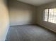 Bedroom with neutral walls, carpet, and a window overlooking the backyard at 3703 N Wintergreen Way, Avondale, AZ 85392