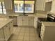 Bright kitchen featuring modern appliances, white cabinetry, a peninsula island, and a double sink beneath a large window at 3703 N Wintergreen Way, Avondale, AZ 85392