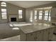 Bright living room with a fireplace, large windows, neutral walls and carpet, and adjoins the kitchen at 3703 N Wintergreen Way, Avondale, AZ 85392