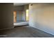 Open-concept living room showcasing neutral walls, carpet flooring, and a glimpse of the kitchen at 3703 N Wintergreen Way, Avondale, AZ 85392