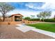 Expansive backyard features a covered outdoor kitchen, lush turf, and desert landscaping at 3826 E Equestrian Trl, Phoenix, AZ 85044