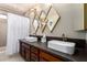 Well-lit bathroom featuring double sinks, modern fixtures, and decorative diamond-shaped mirrors at 3826 E Equestrian Trl, Phoenix, AZ 85044