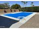 A serene view of a fenced in pool area, complete with privacy hedges and desert landscaping at 3826 E Equestrian Trl, Phoenix, AZ 85044