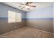 Cozy bedroom with neutral colors, ceiling fan, and window providing natural light at 41955 W Hillman Dr, Maricopa, AZ 85138