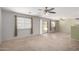 Carpeted Living room with sliding glass doors to back yard and open access to kitchen area at 41955 W Hillman Dr, Maricopa, AZ 85138