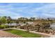 Pool and outdoor recreation area near a lake with palm trees and lush lawns at 42368 W North Star Dr, Maricopa, AZ 85138