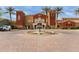 Exterior shot of the attractive clubhouse with a fountain, palm trees, and ample parking at 42368 W North Star Dr, Maricopa, AZ 85138