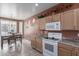 Cozy kitchen featuring wooden cabinets, tile flooring, and a window-lit dining area at 42368 W North Star Dr, Maricopa, AZ 85138