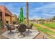 Outdoor dining area with green umbrella, overlooking a pond with beautiful lawn at 42368 W North Star Dr, Maricopa, AZ 85138