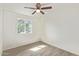 Bedroom features ceiling fan, wood-look floors, and a window overlooking the front yard at 4366 E Burgess Ln, Phoenix, AZ 85042