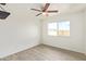 Bright bedroom features updated ceiling fan, flooring, and large window with views of the front yard at 4366 E Burgess Ln, Phoenix, AZ 85042