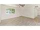 Spacious living room featuring a ceiling fan, light-colored walls, and wood-look tile flooring at 4366 E Burgess Ln, Phoenix, AZ 85042