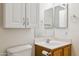 Bright bathroom features a vanity with wooden cabinets, an upper cabinet, and a large frameless mirror at 455 S Mesa Dr # 126, Mesa, AZ 85210