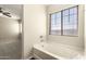 Bright bathroom with a soaking tub near a large window, offering natural light and serene views at 4675 E Olney Ave, Gilbert, AZ 85234