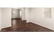 An empty living room with wood-look floors, neutral paint, and a chandelier in the adjacent dining area at 4675 E Olney Ave, Gilbert, AZ 85234