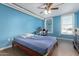 Bedroom featuring blue walls, a ceiling fan, tile floors, and a workspace near a window providing natural light at 535 W Thomas Rd # 313, Phoenix, AZ 85013