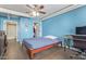 A blue bedroom features tile floors, a bed, workspace, doorways to the bathroom and walk-in closet at 535 W Thomas Rd # 313, Phoenix, AZ 85013