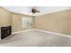 Cozy living room featuring plush carpet, a fireplace, and a ceiling fan at 6159 E Indian School Rd # 110, Scottsdale, AZ 85251