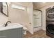 Modern bathroom with a green vanity and stacked washer and dryer at 632 Aero Rd, Mesa, AZ 85205