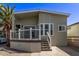 Charming exterior featuring a well-maintained yard, a covered porch with white railings, and mature landscaping at 632 Aero Rd, Mesa, AZ 85205