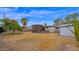 View of the backyard with lattice covered area, lawn, palm and mature tree at 6405 N 46Th Dr, Glendale, AZ 85301