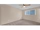 Comfortable bedroom featuring neutral walls, carpet, a window, and a ceiling fan for added air circulation at 6405 N 46Th Dr, Glendale, AZ 85301