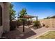 Backyard features a pergola with brick pavers and desert landscaping at 6494 W Matilda Ln, Glendale, AZ 85308