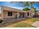 Landscaped backyard with stone pavers and covered patio with neutral-toned stucco at 6494 W Matilda Ln, Glendale, AZ 85308