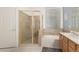 Bright bathroom with a glass-enclosed shower, soaking tub, and natural light at 6494 W Matilda Ln, Glendale, AZ 85308